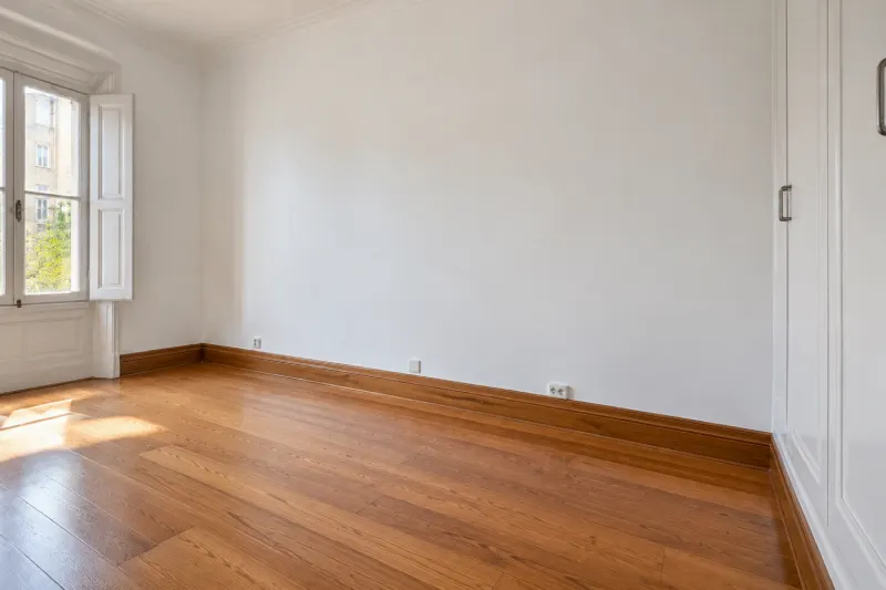 Dormitorio de casa antigua con las paredes re-enyesadas, lisas y pintadas de blanco